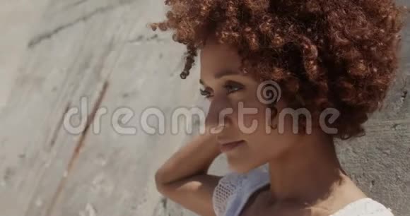 在4k阳光下年轻的非裔美国妇女在海滩上放松的侧面景色视频的预览图