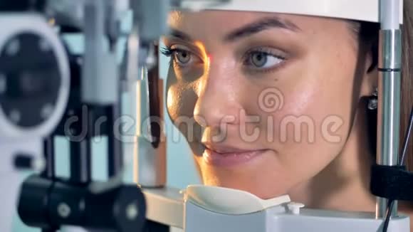在眼科医生办公室进行光学检查时一名妇女睁着眼睛视频的预览图