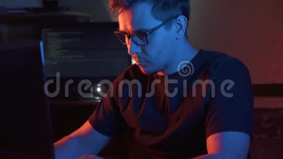 一个戴眼镜的人在黑暗的房间里看着电脑视频的预览图
