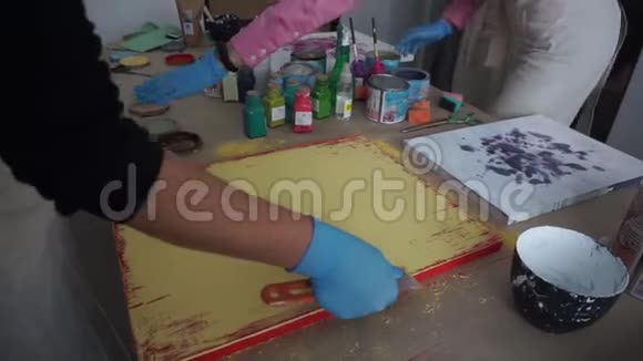 艺术家用铲子刮油漆油漆罐黄色油漆视频的预览图