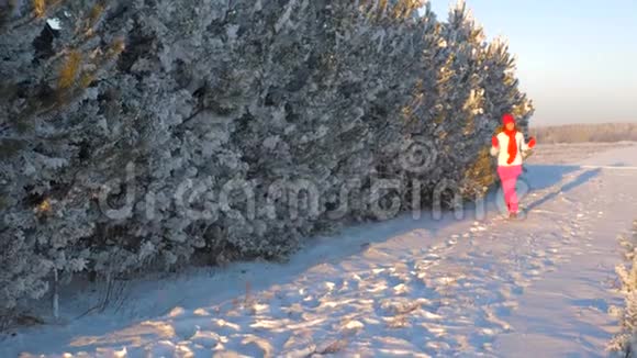 冬天的女人跑到日落的雪前微笑着挥手视频的预览图