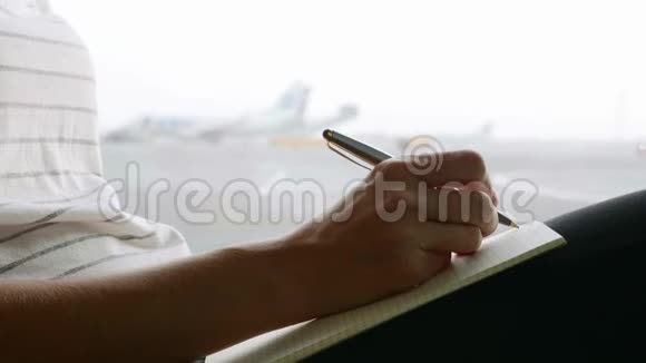 年轻女子在机场写日记慢动作特写视频的预览图