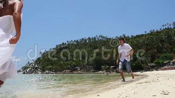 海滩暑假情侣互相跑步节假日拥抱快乐的海滩度假情侣玩得开心视频的预览图