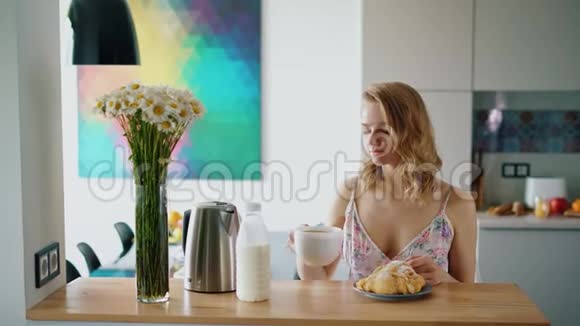 快乐的女孩在家厨房吃早餐美丽的白种人女人视频的预览图