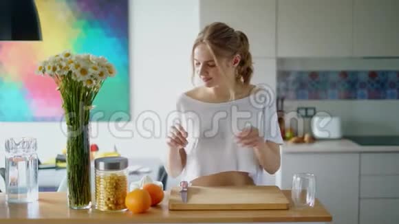 健康的女人在木板上切橘子准备早餐视频的预览图