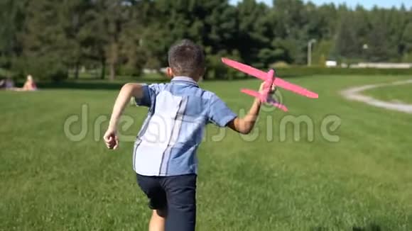 飞行员男孩在公园里发射一架玩具飞机慢动作视频的预览图