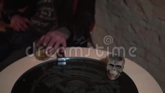 Biker手拿着威士忌酒杯放在打火机和头骨旁边视频的预览图
