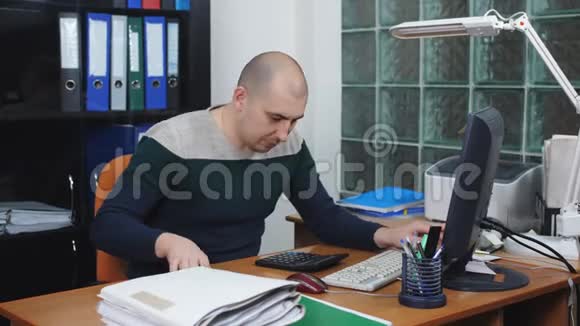 在办公室工作的人用电脑和手机说话视频的预览图
