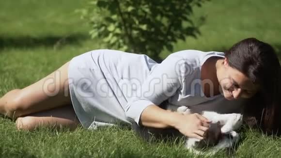 小女孩留着长发在公园里的草地上养了一只小狗心情很好慢动作视频的预览图