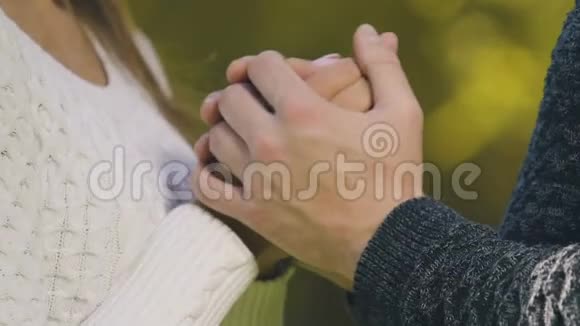 男人温暖女人的手在寒冷的秋日关心的关系特写视频的预览图