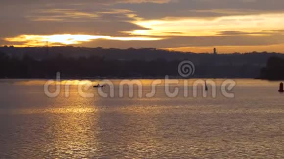 美丽的日落和渔夫船水上的孤独水上浮标的剪影视频的预览图