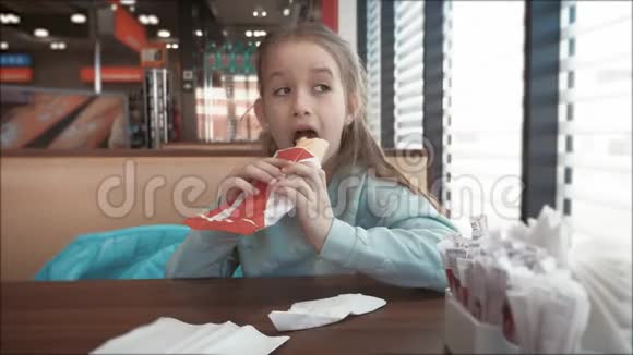 漂亮的女孩在路边的咖啡馆里吃热狗快餐在汽车旅行的概念视频的预览图
