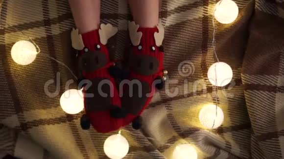 圣诞装饰以滑稽鹿的形式编织袜子特写镜头孩子们脚穿着袜子的背景视频的预览图