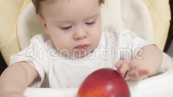 小孩子正坐在桌子旁玩红苹果视频的预览图
