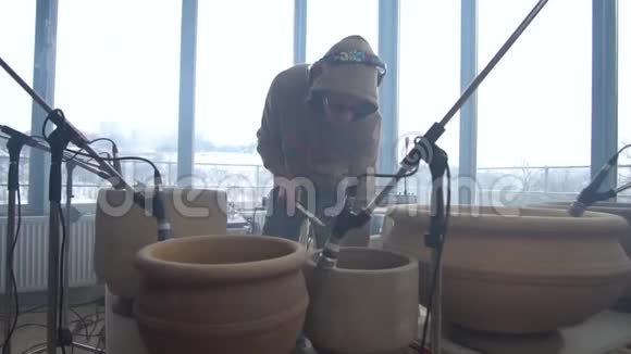 一个穿着运动衫的人拿起鼓棒在陶罐上玩耍视频的预览图