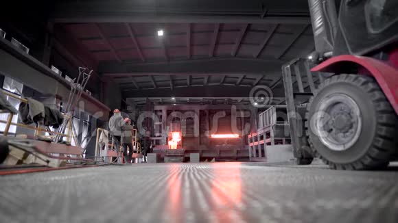 冶金生产现场在阴沉的商店里工人们监视着炉子的运行在炉子下面视频的预览图