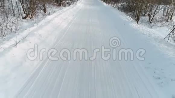 冬季道路上覆盖着雪空中镜头相机向后移动视频的预览图