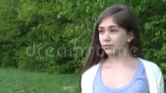 悲伤的脸美丽的年轻女孩看着公园里的户外特写的严肃少年的肖像视频的预览图