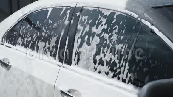 洗车过程发泡洗涤剂覆盖机器从污垢中清洗慢动作视频的预览图