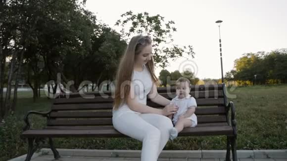 公园里坐在长凳上的母女动作缓慢视频的预览图