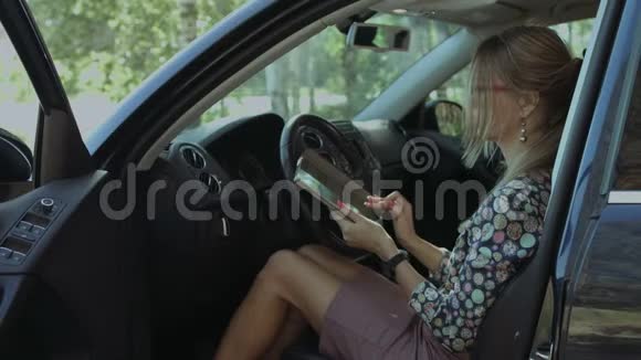 在车里用平板电脑建立迷人的女性网络视频的预览图