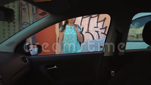 女人在汽车座椅上穿上夹克坐在驾驶座打算发动引擎视频的预览图