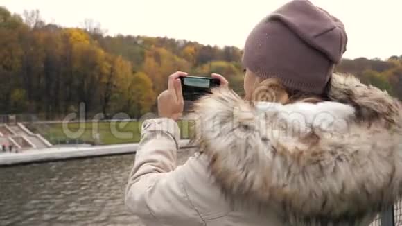 漂浮在船上的妇女在河上拍摄一个海岸色彩缤纷的秋天公园视频的预览图