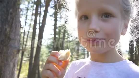 特写一个美丽的年轻女孩的肖像在暑假里享受和吃一个新鲜的三明治视频的预览图
