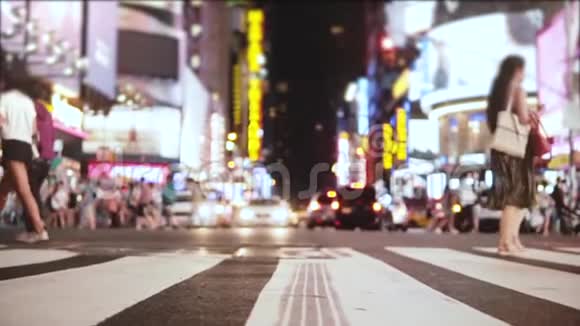 惊人的低角度慢动作镜头的人群走过街道与许多广告在晚上在时代广场纽约视频的预览图