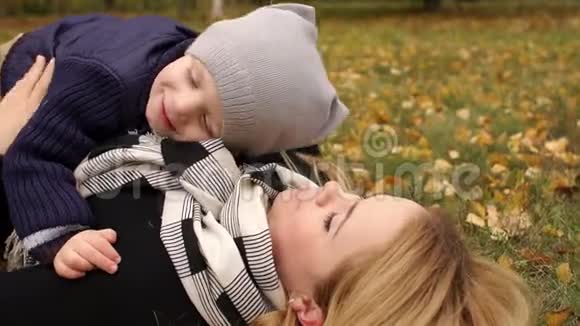 在公园秋天幸福的家庭躺在草地上视频的预览图