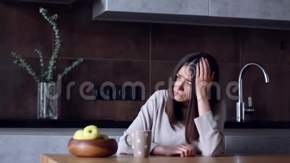 坐在厨房头痛的女人视频的预览图