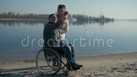 残疾人和女孩拍照自拍微笑瘸子近河视频的预览图