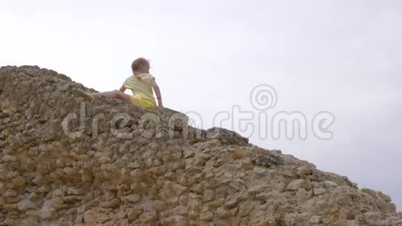 少女坐在岩石楼梯上边走边挥手视频的预览图