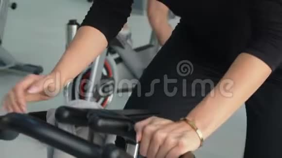 健身妇女在自行车课上进行室内自行车训练团体运动的人在自行车健身房旋转自行车心脏培训视频的预览图