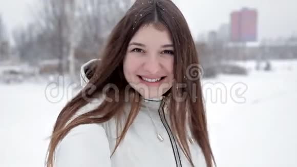 年轻开朗的女孩在公园的冬天散步在雪地里玩耍寒冷视频的预览图