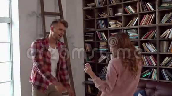 年轻的一对夫妇在家一起在情人节在图书馆玩的概念视频的预览图
