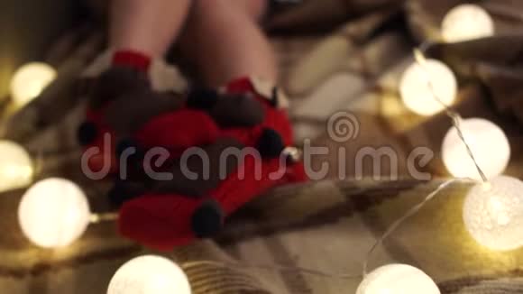 一个穿着针织袜子的小孩摆动腿的特写镜头圣诞老人鹿创意圣诞装饰视频的预览图
