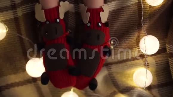 以滑稽鹿的形式编织袜子特写镜头孩子们在格子地毯的背景下穿着袜子脚视频的预览图