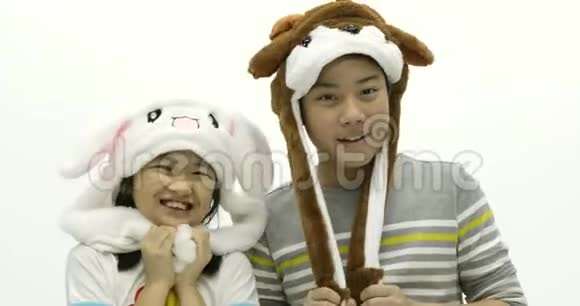 亚洲兄妹戴着漂亮帽子面带笑容的肖像视频的预览图