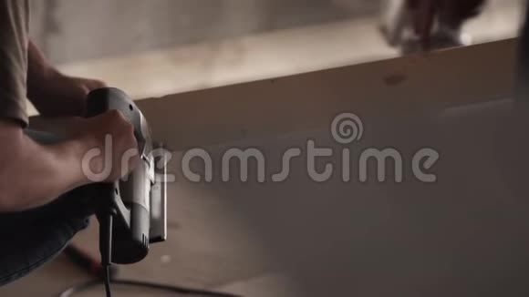 男的手正在用机械工具在工作间的木板上劳动视频的预览图