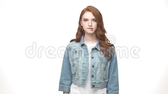 考虑周到的漂亮红头发的女人站在一边很难选择而孤立地站在白色的背景上视频的预览图