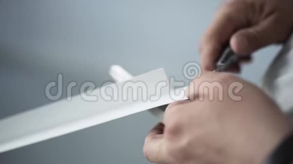 男人手拿着一块白色塑料剪刀和建筑刀视频的预览图