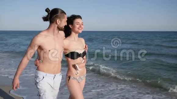 男人手牵着女孩赤脚走在沙滩上情侣相爱异国情调的度假背景沙滩全景视频的预览图