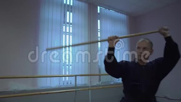 剑道大师用木棍表演剑塔一大早就在大厅里训练视频的预览图