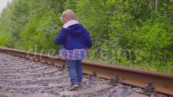 男孩在铁路上行走危险的游戏和娱乐活动夏日视频的预览图