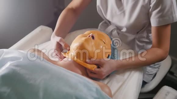 美容师从顾客脸上摘下水果面具美容师视频的预览图