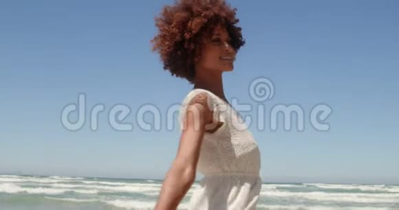 年轻的非裔美国妇女在阳光下海滩上玩得开心的正面景色视频的预览图