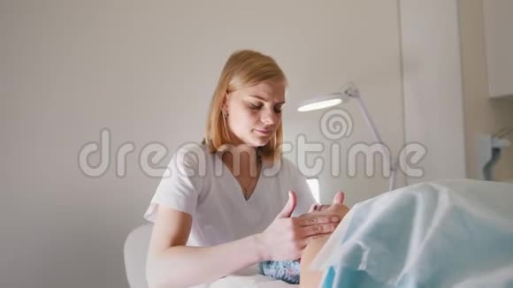 美容师在美容院按摩客户脸部和颈部视频的预览图