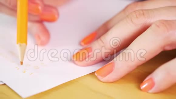女人拿着一支橙色的铅笔在白纸上做笔记视频的预览图