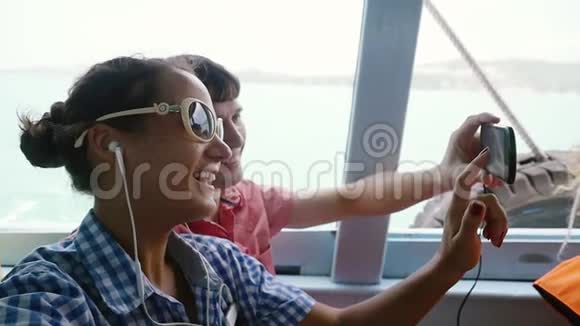 快乐的一对戴太阳镜的夫妇在度假时用手机微笑自拍慢动作1920x1080视频的预览图